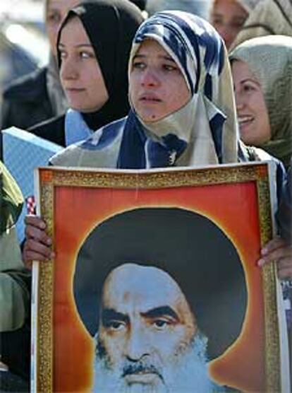 Una mujer porta un cartel del ayatolá Sistani.