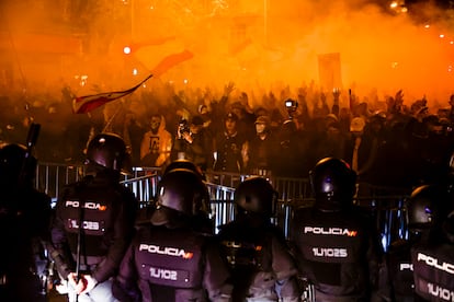 Un grupo de agentes, en fila frente a la valla y a los manifestantes concentrados en los alrededores de la sede del PSOE en la calle de Ferraz de Madrid, este martes.
