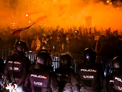 Un grupo de agentes, en fila frente a la valla y a los manifestantes concentrados en los alrededores de la sede del PSOE en la calle de Ferraz de Madrid, este martes.