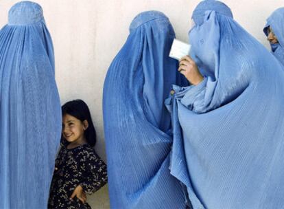 Mujeres afganas en un colegio de Herat, al oeste del país, tras depositar su voto. Una de ellas muestra a la cámara la tarjeta de electora.