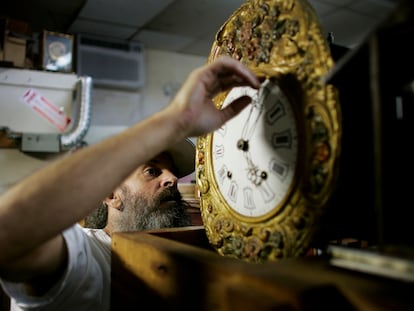 A man adjusts the time on a clock, in the city of Plantation (Florida).