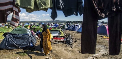 Una mujer camina junto a ropa tendida en el campamento de refugiados de Idomeni, en la frontera entre Grecia y Macedonia.