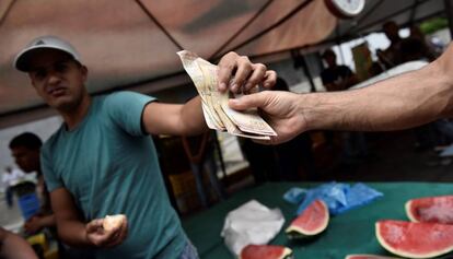 Venezolanos compran comida en un mercado de Caracas. 