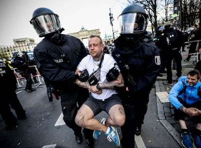 La policía se lleva detenido a un manifestante en la protesta de este miércoles en Berlín contra las nuevas restricciones que ha aprobado el Parlamento alemán.