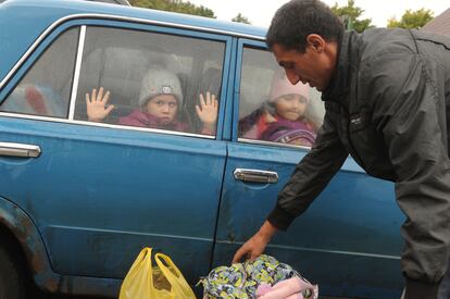 Unos niños miran por la ventana de un coche a su llegada a un campo de refugiados ucranios procedentes de la región de Járkov en la ciudad rusa de Bélgorod, el miércoles.