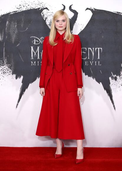 Elle Fanning nos está dejando estilismos para el recuerdo mientras promociona por todo el mundo Maléfica, maestra del mal. El último, un total look rojo compuesto por americana, camisa, corbata y pantalones culotte, todo de Gucci.