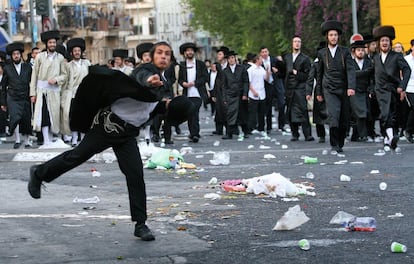 Unos ultraortodoxos se manifiestan en la calle lanzando piedras.