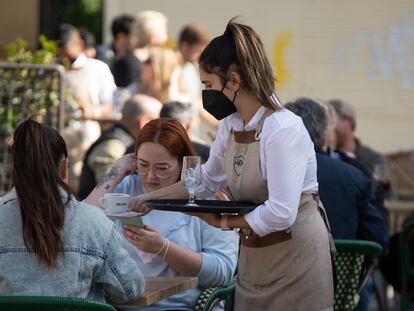 Una camarera atiende una terraza en el centro de Sevilla.