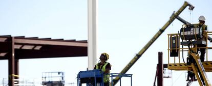 Obreros trabajan con maquinaria de construcción.