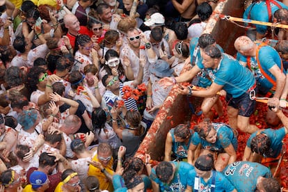 Varios participantes de la Tomatina lanzan tomates desde un camión a las personas que se encuentran cerca, en Buñol el año pasado.