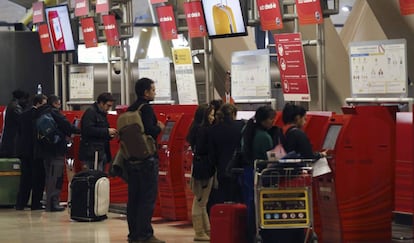 Varias personas, en los mostradores de facturaci&oacute;n de Iberia de la T4 del aeropuerto de Madrid-Barajas. 