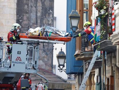 Los bomberos rescatan a uno de los heridos en el derrumbe de un edificio en el Casco Viejo de Bilbao, este jueves.