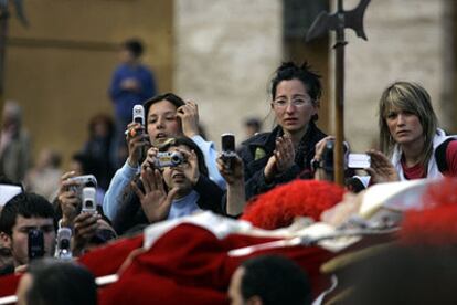 Algunos fieles fotografían el cadáver del Papa mientras es trasladado a la basílica de San Pedro.