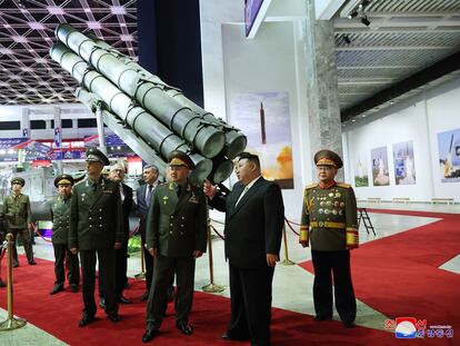 El líder norcoreano, Kim Jong-un (de traje) charla con el ministro de Defensa ruso, Serguéi Shoigú (a su derecha), durante la visita el miércoles a una exposición de armamento en Pyongyang.