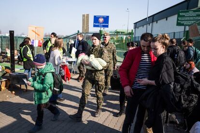 Un soldado polaco ayuda a una madre a llevar a su bebé en la frontera de Medyka, entre Polonia y Ucrania. Este es uno de los principales puntos por donde escapan los ciudadanos ucranios de las bombas de Rusia, que invadió su país el 24 de febrero. Y cuando los refugiados llegan, escuchan música de piano...