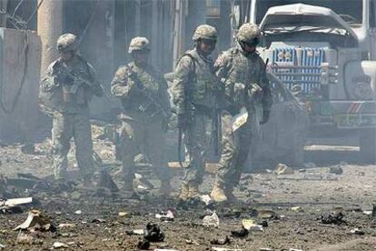 Soldados de EE UU inspeccionan el lugar de un atentado que causó 20 heridos ayer en Mosul, en el norte de Irak.