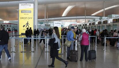 Decenas de pasajeros ante los puestos de facturaci&oacute;n de Vueling en el aeropuerto de Barcelona-El Prat.