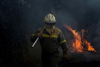 Un bombero trabaja en el incendio forestal en la localidad de Cualedro, en Ourense. La voracidad de las llamas alertó a los bomberos portugueses que se desplazaron hasta la localidad orensana para tratar de evitar que las llamas cruzasen hasta el país vecino.