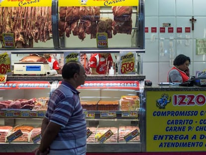 Homem olha carnes em mostrador em S&atilde;o Paulo.