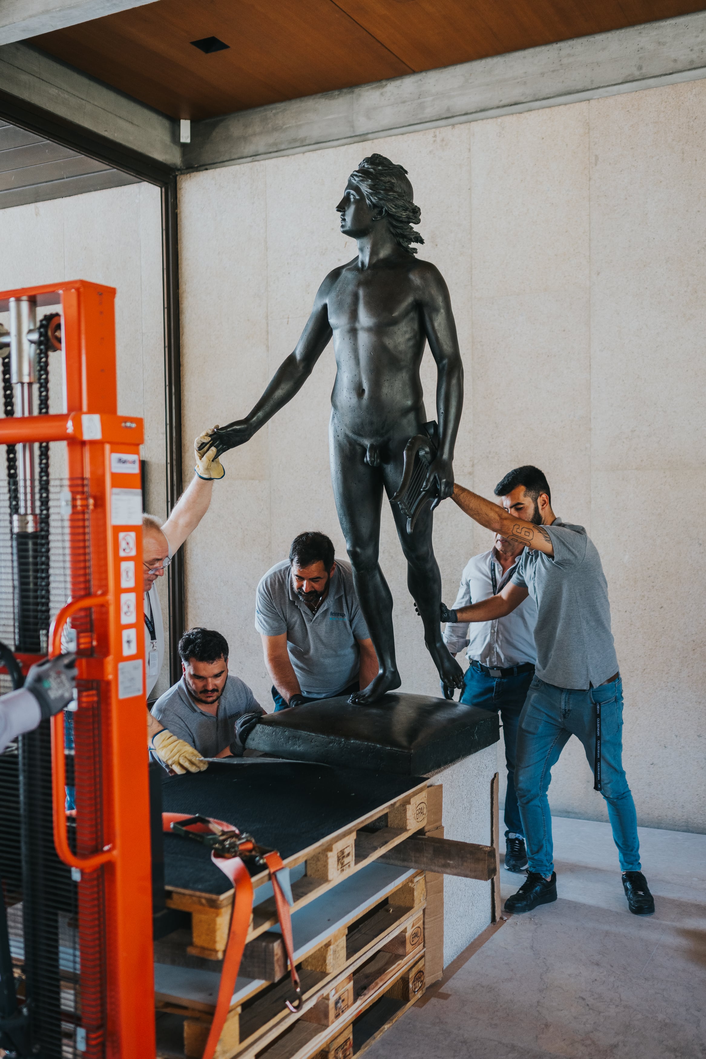 Varios trabajadores colocan una estatua tras la renovación de las salas del museo.