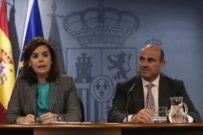 La vicepresidenta del Gobierno, Soraya Sáenz de Santamaría, y el ministro de Economía, Luis de Guindos, durante una rueda de prensa posterior al Consejo de ministros.