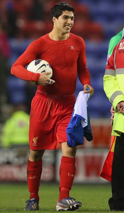 Luis Suarez con el balón después de hacer un hat trick ente el Wigan.
