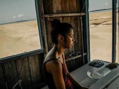 Elidia Carolina at her home on the banks of the Solimões River in the Brazilian Amazon. Due to the drought, the area surrounding her home resembles a desert.