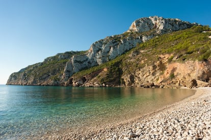 Toma la apariencia de una piscina en la desembocadura de dos barrancos. Y aunque la mitad de la cala (la que jamás figura en las fotos) esté urbanizada, bajar a La Granadella despierta la más profunda impresión. Chapuzar en sus aguas entraña perder pie a los pocos metros. A unos 20, mar adentro, las piedrecillas dejan paso a un lecho de arena. Abundan los servicios. Y el sonido de los cantos rodados yendo y viniendo por las olas posee aquí una calidad estupefaciente. En julio se corta el acceso y presta servicio un autobús lanzadera. Nada mejor que celebrar con una caldereta el 60º aniversario del <a href="https://www.restaurantesur.com/" target="">restaurante Sur.</a>