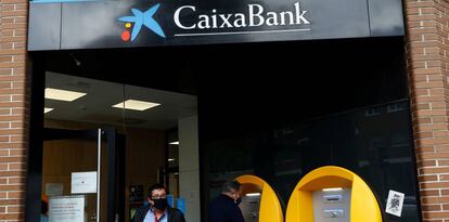 Clientes de CaixaBank en la puerta de una sucursal de la entidad financiera en Madrid.