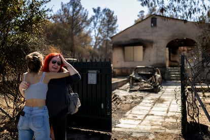 Una mujer es consolada frente a su casa incendiada por el fuego en Ano Patima, cerca de Penteli, en el norte de Atenas.