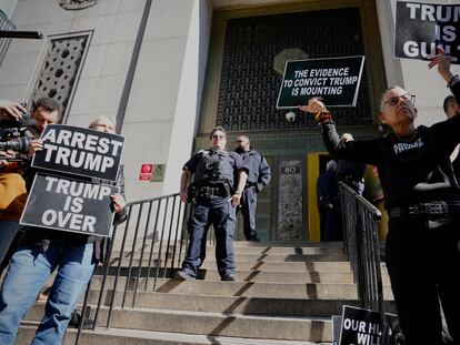 Protesters hold signs on the steps in front of the New York City administration building on March 20, 2023, in New York.