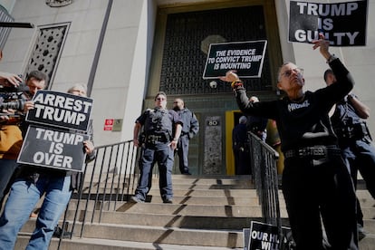 Protesters hold signs on the steps in front of the New York City administration building