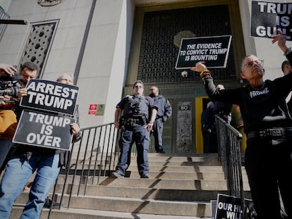 Protesters hold signs on the steps in front of the New York City administration building on March 20, 2023, in New York.