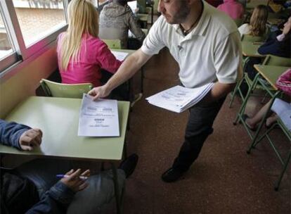 Un profesor reparte exámenes de Ciudadanía en un instituto de Madrid.
