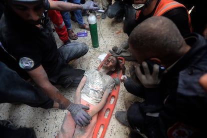 Personal de rescate atiende a una niña herida tras ser rescatada de los escombros de un edificio en Jan Yunis, este martes.