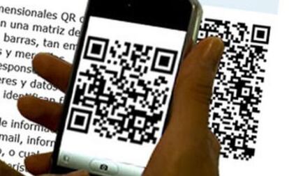 Una mujer capta un c&oacute;digo QR con su m&oacute;vil.