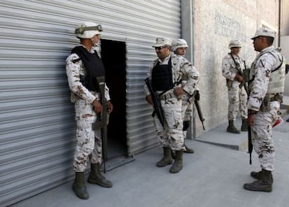 Soldiers guard the entrance of the warehouse where the secret tunnel was being constructed.