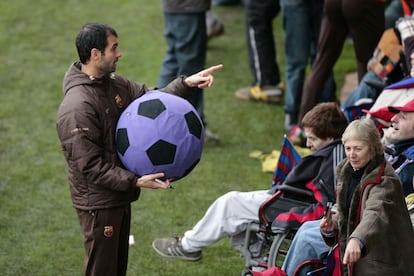 Josep Guardiola, durante un entrenamiento de su equipo, se dirige a la afici&oacute;n. 