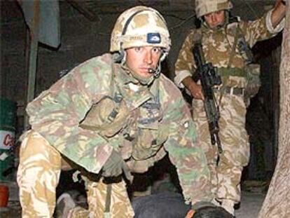 Un soldado británico sujeta a un prisionero iraquí, capturado durante un registro nocturno en Um Qasr.