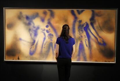 Una mujer observa una pintura, valorada en casi 30 millones de euros, del pintor francés Yves Klein.