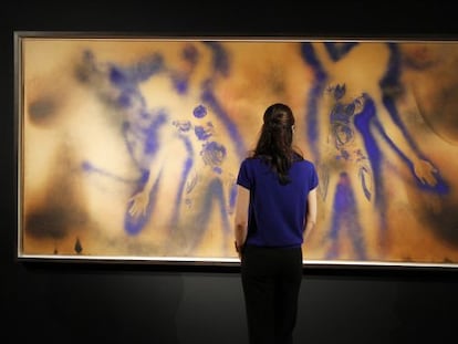 Una mujer observa una pintura, valorada en casi 30 millones de euros, del pintor franc&eacute;s Yves Klein. 