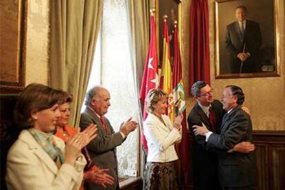 Alberto Ruiz-Gallardón abraza a José María Álvarez del Manzano ante la atenta mirada de Esperanza Aguirre.