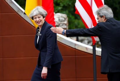 El primer ministro italiano Paolo Gentiloni le muestra el camino a la primera ministra británica Theresa May.