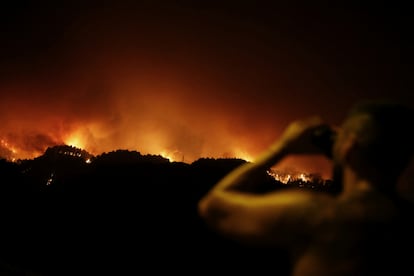 Un joven observaba con prismáticos el incendio en La victoria, el sábado.