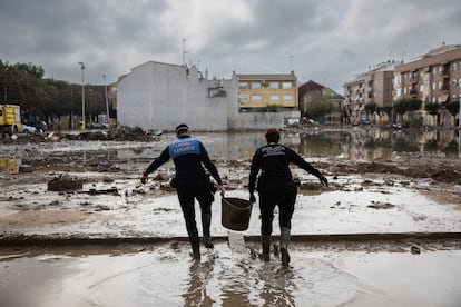 Dos policías trabajan en las tareas de limpieza de un garaje del centro de Paiporta (Valencia) este jueves.