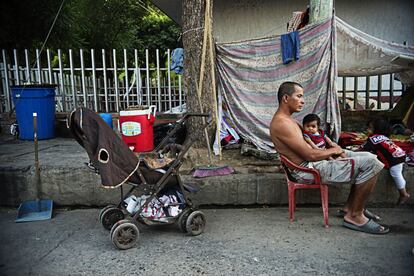 Jhon Jairo Beltr&aacute;n con el menor de sus hijos en el campamento improvisado donde vive en C&uacute;cuta, Colombia.