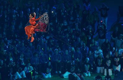 La cantante de Barbados Rihanna en un momento de su actuación mientras sobrevuela en un columpio a los atletas.