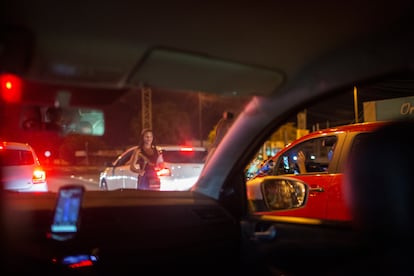 Jovens venezuelanas trabalham informalmente limpando vidros de carros nas ruas de Boa Vista, Brasil.