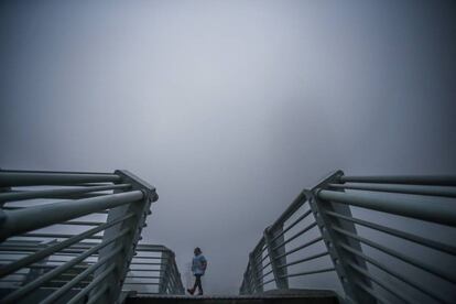 Una niña camina entre la contaminación en un puente de Hefei (China).