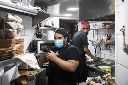 Trabajadores en el restaurante de comida venezolana El rincon de la Abuela Venezolana, durante la recepción de un pedido.